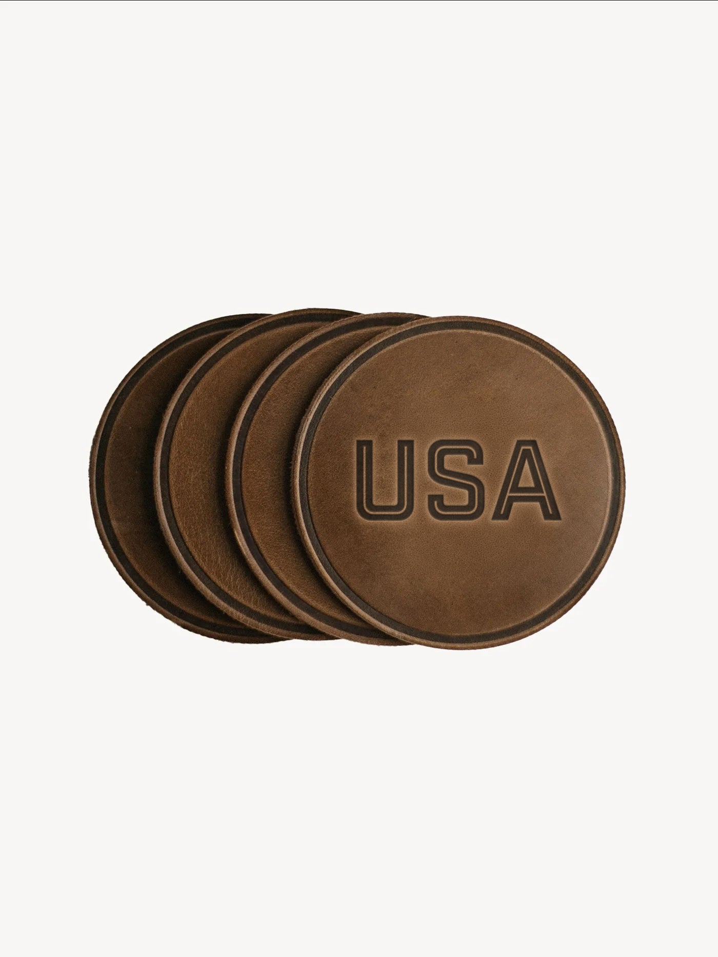Set of four brown leather coasters with 'USA' engraving on a white background