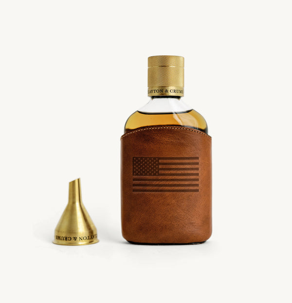 Flask leather case and gold cap on white background